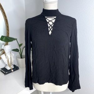 Black long sleeve blouse with cross cross design across chest